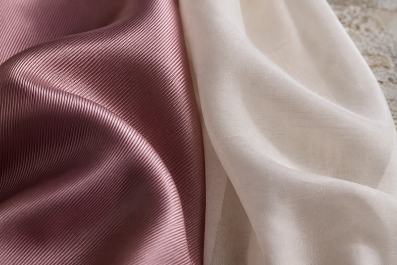 Two scarf fabrics shown side by side, with diagonal twill ridges contrasted against a lighter, softly draped plain weave.