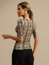 Woman wearing a beige snake print silk scoop neck top with half sleeves