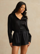 Model wearing black 19 momme silk high-waist A-line shorts with shirred drawstring waist and side pockets