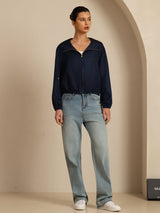 Navy silk hooded jacket with stand collar, front zip and pockets, styled with jeans