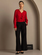 Red silk-wool blend blouse with black straight-fit pants and side pockets
