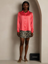 Women’s pink silk lapel collar long sleeve shirt with button front, styled with mini skirt
