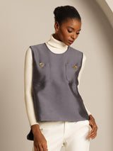 Gray silk-wool blend women's vest with button pockets over a cream turtleneck