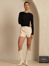 Black silk jersey women's mock neck long sleeve top styled with cream shorts