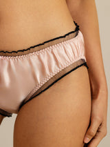 Blush pink silk low-rise panty with sheer black ruffle trim and elastic waistband