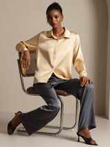 Model wearing champagne silk long sleeve lapel collar blouse with black pants