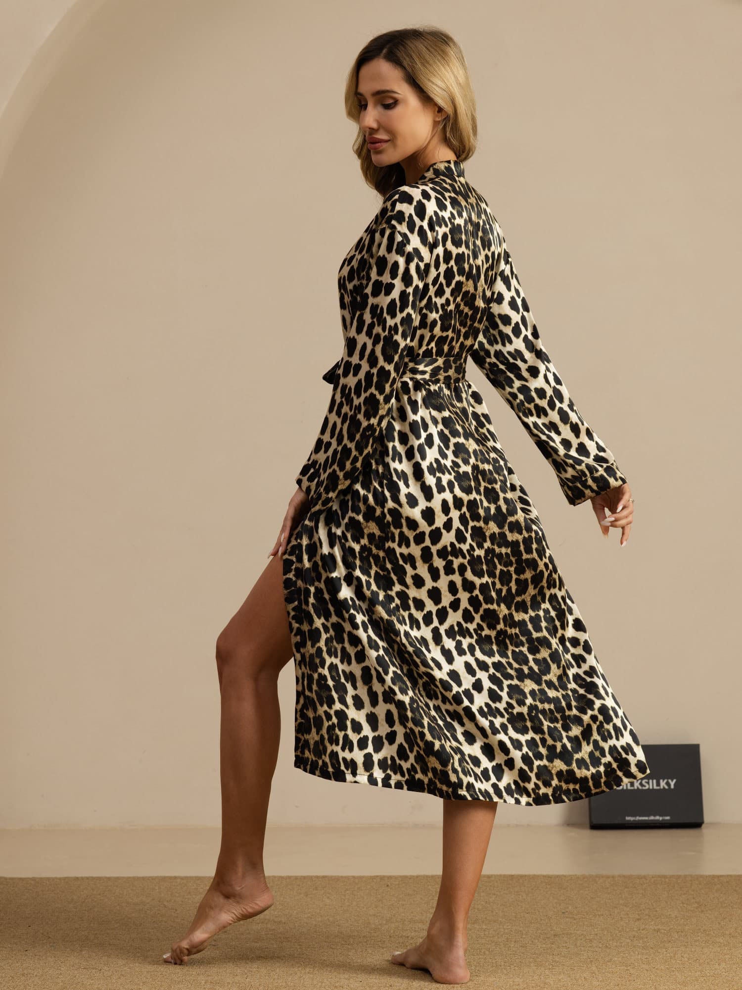Woman wearing a pure silk leopard print midi robe with belted waist and long sleeves