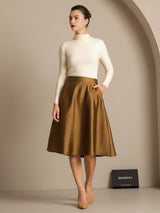 Model wearing a camel silk-wool blend A-line midi skirt with a cream ribbed turtleneck