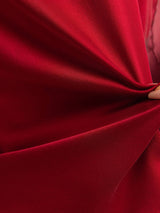 Deep red silk blend fabric gathered in a close-up drape, showing a smooth, lustrous texture