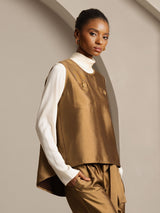 Brown silk-wool blend women's vest with button pockets layered over a white long-sleeve top