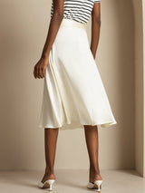 Cream silk high-waist A-line midi skirt with pockets, worn with striped top and heels