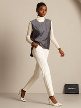 Gray silk-wool blend women's vest with button pocket design, styled over cream turtleneck and white pants