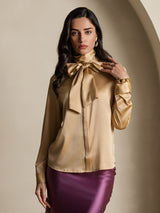 Champagne silk long sleeve high neck blouse with oversized bow tie and buttoned cuffs