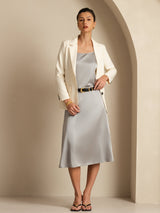 High-waist A-line midi silk skirt in light gray with pockets, styled with a cream blazer