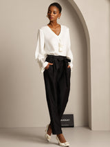 White silk-blend blouse with black high-waist tapered cropped pants and tie waist