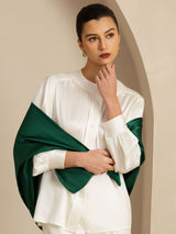 Woman wearing white silk blouse with dark green scarf-style drape