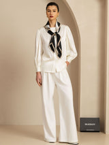 White silk blouse and pants with black ribbon-print square scarf