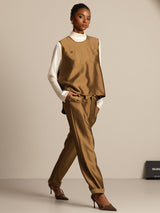 Camel silk-wool blend vest with button pockets, styled with matching trousers and white turtleneck
