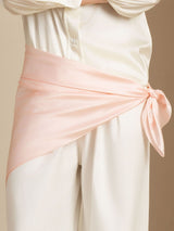 Soft peach 100% mulberry silk square scarf tied at the waist over cream silk clothing