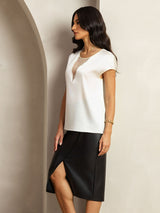 White silk cap sleeve top with sheer V insert, worn with black skirt