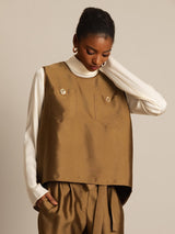 Camel silk-wool blend women's vest with button pockets over a cream long-sleeve top