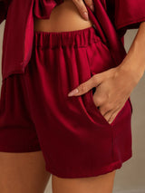 Burgundy silk pajama shorts with elastic waist and side pockets
