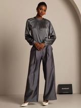 Model wearing charcoal silk-wool blend wide-leg pants with side pockets